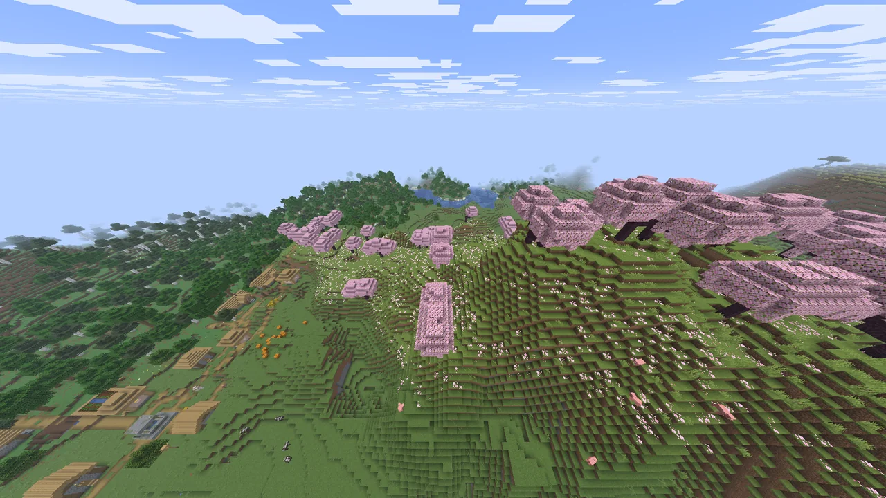Pink cherry trees on a hillside beside a village and a river.